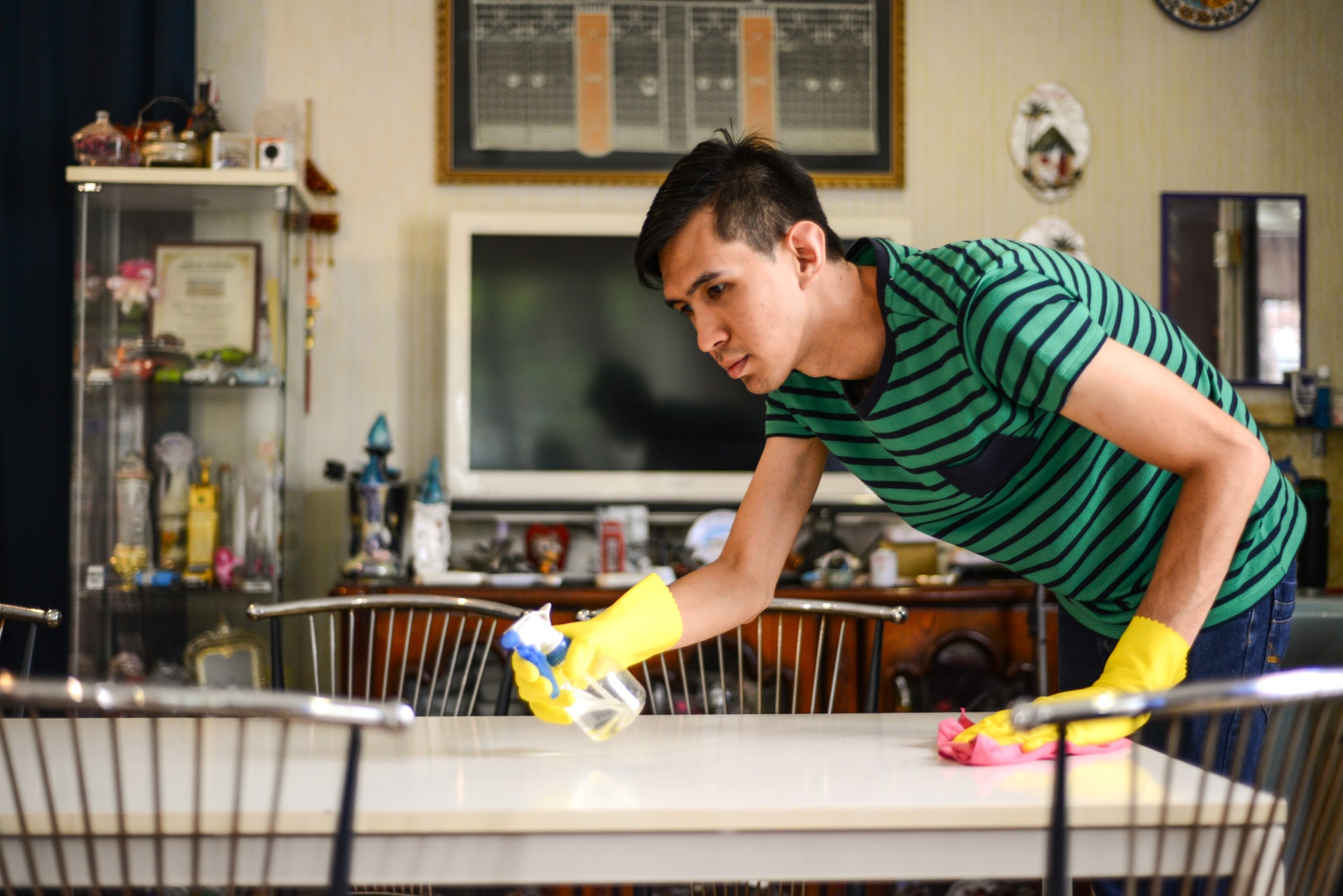 Asian young man cleaning the table at home