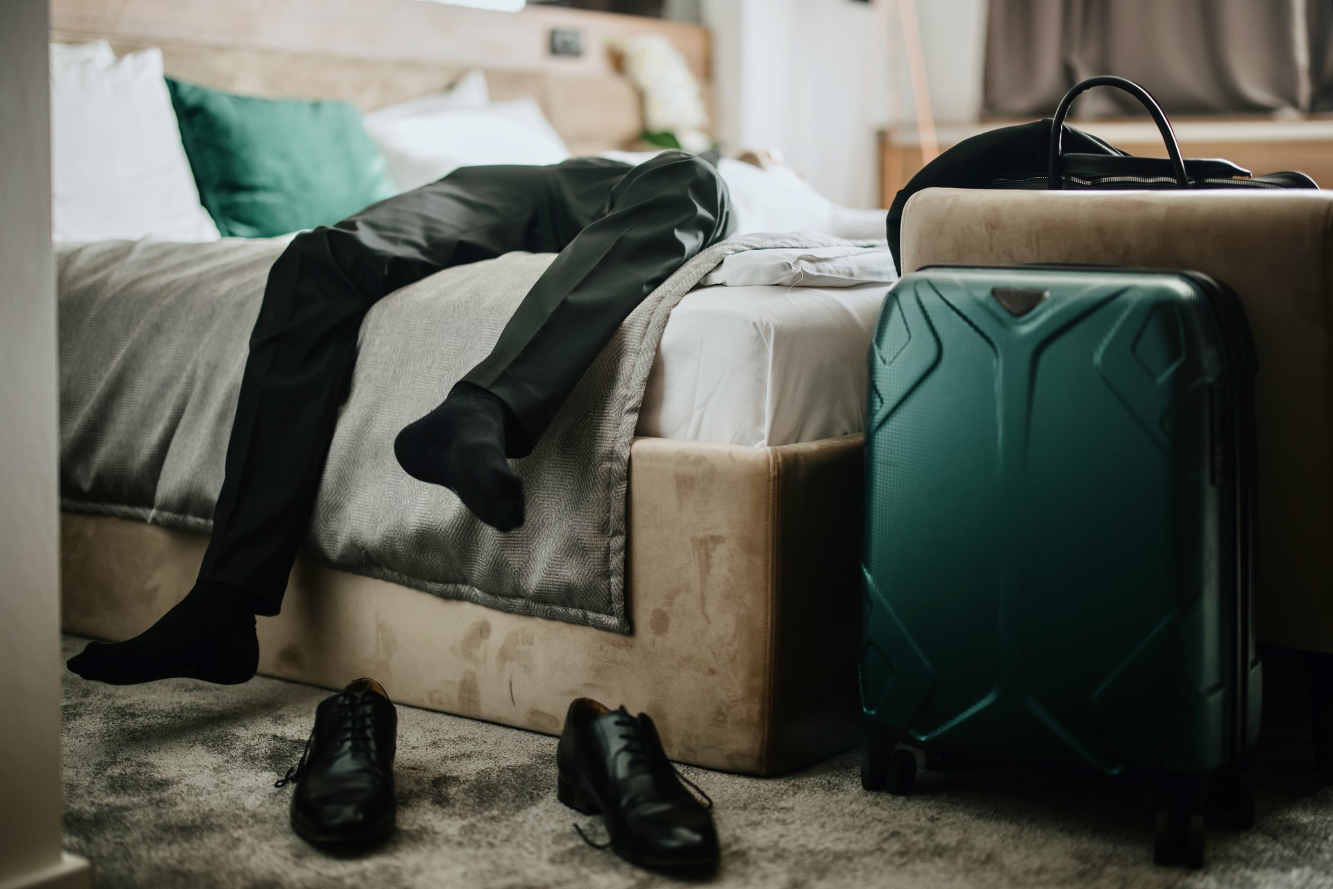 Business traveler lying on the bed exhausted from the business trip in the hotel room